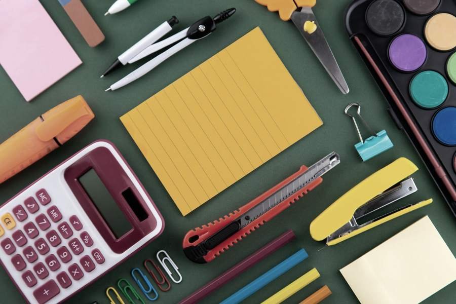 Office stationery including notepads, pens, stapler and calculator